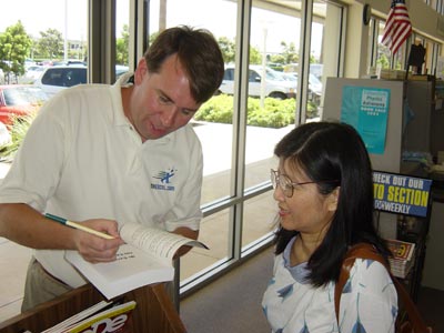 Bill signs a book for Anh